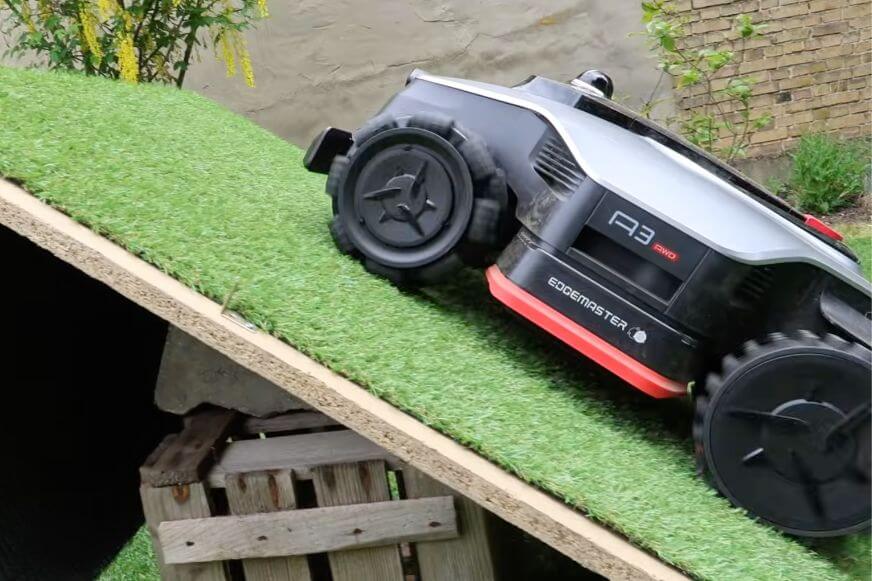 Dreame A3 AWD Pro 3500 fährt eine Rampe mit Kunstrasen bei 80% Steigung hoch